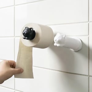 May include: A quirky toilet roll holder with a black cat figure emerging from the roll and a white cat-shaped arm. The holder is mounted on a white tiled wall. This design adds a playful touch to bathroom decor.