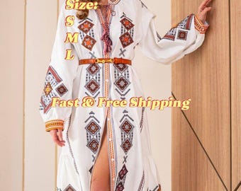 May include: White maxi dress with embroidered detail, featuring a brown belt and long sleeves. The dress has a geometric pattern and a button-up front. The text "Size: S M L" and "Fast & Free Shipping" is visible on the image.