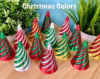 May include: A collection of cone-shaped ornaments featuring spiral ridges in various metallic color combinations including red, green, silver, and gold. The text "Christmas Colors" is displayed at the top of the image above the ornaments.