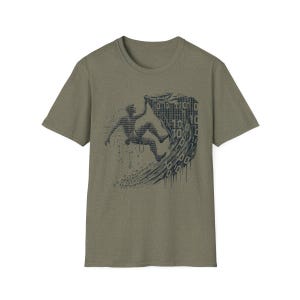 Peut inclure: Un t-shirt vert avec un motif représentant une personne surfant sur une vague faite de code binaire. Le motif est dans des tons de bleu et de noir.