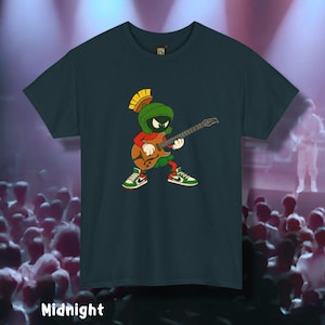 May include: Midnight blue t-shirt featuring a cartoon character playing a guitar. The character is wearing a green helmet, red shirt, and green and white sneakers. The guitar is brown and orange. The word "Midnight" is printed at the bottom of the shirt.