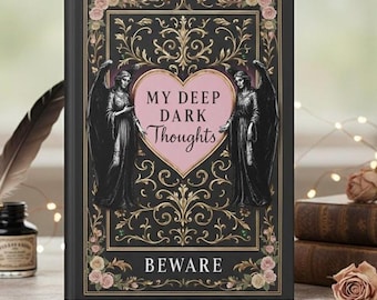 Può includere: Un diario con copertina rigida nera con filigrana dorata, due figure di angeli e la scritta "MY DEEP DARK Thoughts" all'interno di un cuore rosa. La parola "BEWARE" è in basso, con accenti floreali.