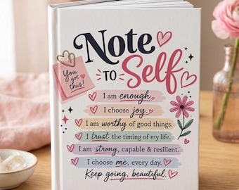 May include: A white hardcover journal with the title Note to Self in dark blue and pink script. The cover features a pink sticky note graphic with the text You got this and five colorful horizontal bars with affirmations and small heart icons.