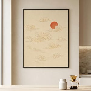 Può includere: Una stampa artistica da parete incorniciata con sfondo beige, caratterizzata da una serie di nuvole stilizzate e vorticose in tonalità marrone chiaro e un sole rosso circolare e solido posizionato nel quadrante superiore destro.