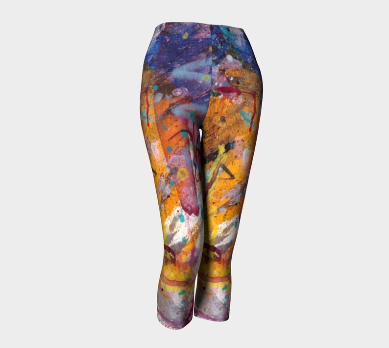 Cropped leggings with a colorful abstract paint splatter design in shades of yellow, orange, blue, purple, and white.