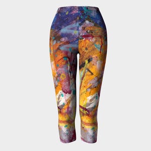 Cropped leggings with a colorful abstract paint splatter design in shades of yellow, orange, blue, purple, and white.