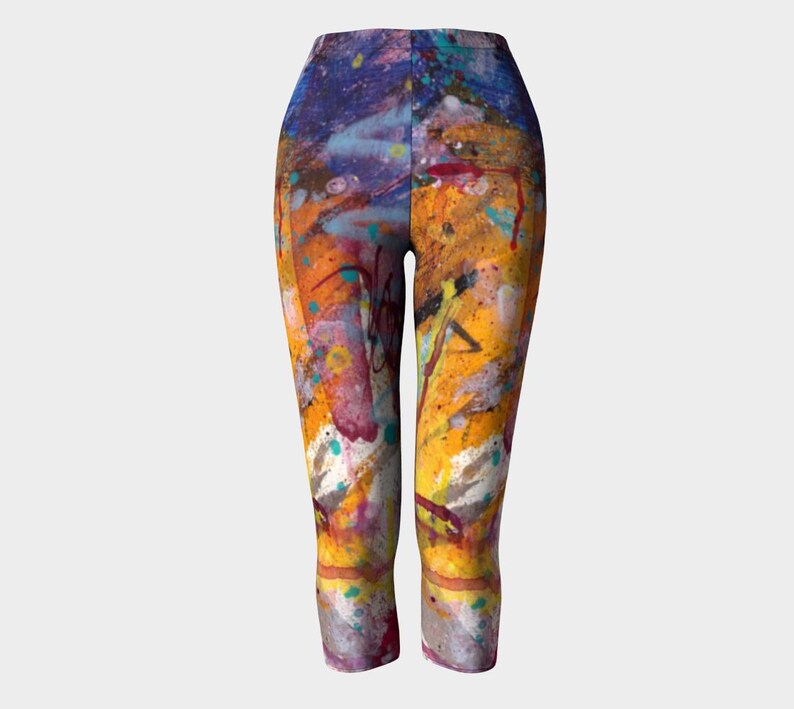 Cropped leggings with a colorful abstract paint splatter design in shades of yellow, orange, blue, purple, and white.