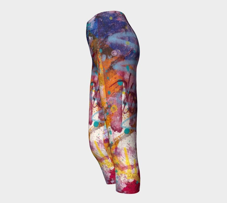 Cropped leggings with a colorful abstract paint splatter design in shades of yellow, orange, blue, purple, and white.