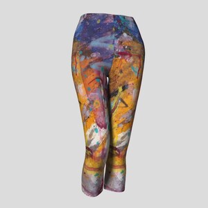 Cropped leggings with a colorful abstract paint splatter design in shades of yellow, orange, blue, purple, and white.