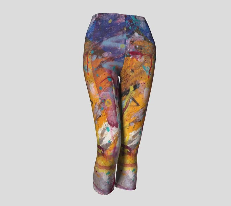 Cropped leggings with a colorful abstract paint splatter design in shades of yellow, orange, blue, purple, and white.
