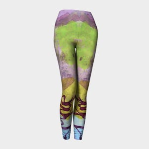 May include: Abstract print leggings with a yellow, green, purple, and blue design. The leggings have a high waist and a tight fit.