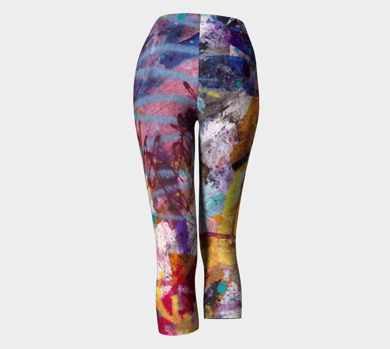 Colorful abstract print leggings with a cropped length. The leggings have a blue, pink, yellow, green, and purple color scheme with a paint splatter design.