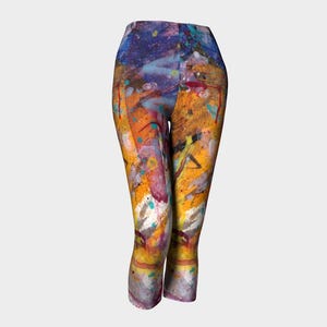 May include: Colorful abstract print leggings with a mix of yellow, orange, blue, purple, and white paint splatters.