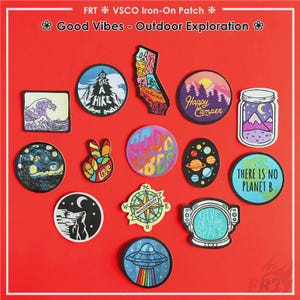 May include: A selection of vibrant iron-on patches featuring diverse designs such as a wave, a mountain landscape, a jar with a mountain, a peace sign, a compass, and a spaceship. The patches include text like "Good Vibes" and "Give Me Some Space."