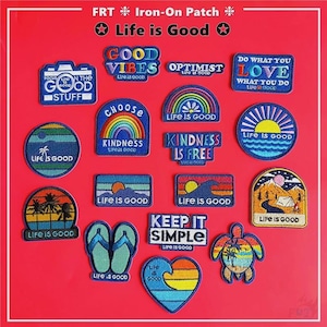 May include: A selection of iron-on patches with the slogan "Life is Good." Patches display phrases such as "Good Vibes," "Optimist," and "Do What You Love." Designs include a camera, rainbow, ocean, and a turtle, all on a red background.