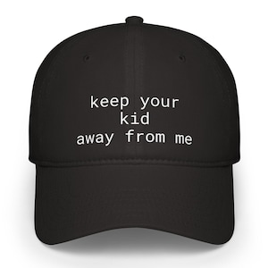 May include: Black baseball cap with the text "keep your kid away from me" in white. The cap has a curved brim and a rounded crown. The text is centered on the front of the cap.