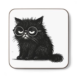 May include: Square coaster featuring a black and white illustration of a grumpy-looking black cat wearing round glasses. The cat has a fluffy appearance and is sitting down. The coaster has a white background and a brown border.