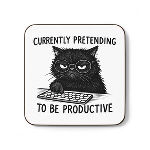 May include: Square coaster with a black cat wearing glasses and a keyboard. The text reads "CURRENTLY PRETENDING TO BE PRODUCTIVE" in black, bold font. The coaster has a white background and a brown border.