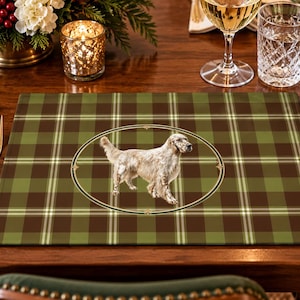 Op de afbeelding: Een rechthoekige placemat met een groen en bruin ruitpatroon en een centraal rond embleem met een illustratie van een lichtgekleurde Engelse Setter die in profiel tegen een donkere achtergrond staat.