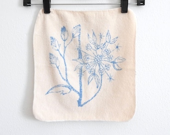 Toallita facial con flores azules, estilo vintage.