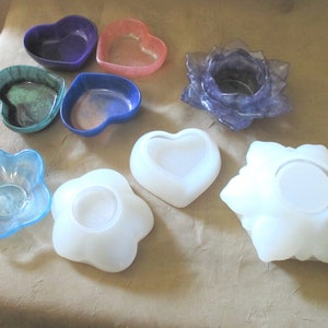 May include: Assortment of colorful resin candle holders in various shapes, including hearts, flowers, and a star. The candle holders are made of clear resin with a variety of colors and patterns.