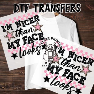 May include: White long-sleeve shirt with a DTF transfer design. The design includes the text "I'M NICER than MY FACE looks" with pink stars and a black star. The image also shows a transfer sheet with the same design.