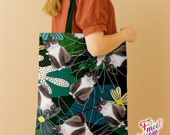 May include: A tote bag featuring a pattern of gray and white cats amidst green leaves and yellow flowers. The bag has a dark green strap and the words "Fa meet Meow" in a playful font.