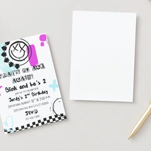 May include: A birthday invitation with the text "WHAT'S MY AGE AGAIN? Blink and he's 2" in a graffiti style. The invitation includes the date, time, and location. A blank card and a gold pen are also present.