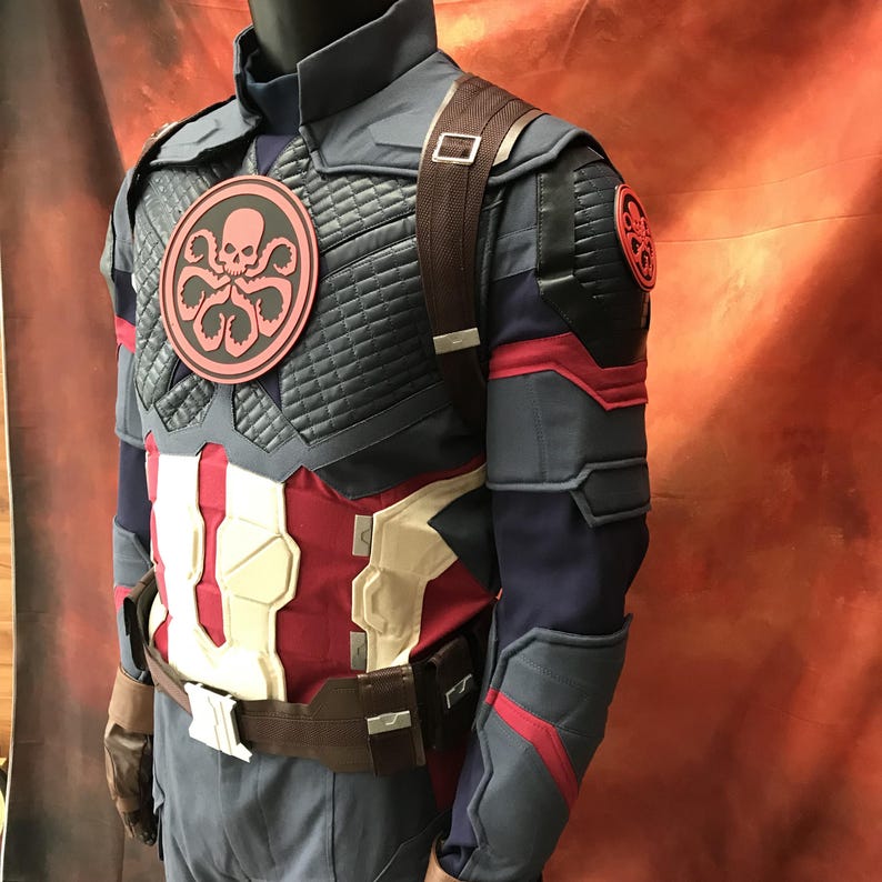 May include: A tactical costume jacket featuring a dark blue and red color scheme with a quilted chest panel. A circular red and black Hydra logo is centered on the chest and on the shoulder. The garment includes a brown utility belt and straps.