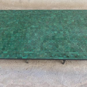 Puede incluir: Una mesa rectangular con un tablero de mosaico compuesto por numerosas piezas peque&ntilde;as en tonos verdes dispuestas en un patr&oacute;n geom&eacute;trico repetitivo. La superficie muestra varias tonalidades de verde esmeralda y bosque sobre un marco de metal.