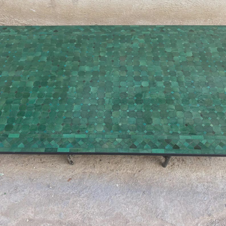 Puede incluir: Una mesa rectangular con un tablero de mosaico compuesto por numerosas piezas peque&ntilde;as en tonos verdes dispuestas en un patr&oacute;n geom&eacute;trico repetitivo. La superficie muestra varias tonalidades de verde esmeralda y bosque sobre un marco de metal.