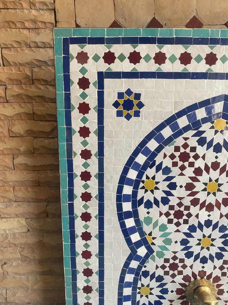 Puede incluir: Un panel de mosaico con un dise&ntilde;o geom&eacute;trico. El panel presenta un fondo blanco con azulejos azules, rojos, amarillos y verdes. El borde es turquesa. El dise&ntilde;o incluye estrellas y patrones arqueados.