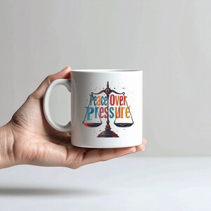 May include: A white ceramic mug with a black handle and the text "But First, Coffee" in a black, handwritten-style font. The mug is on a white surface.