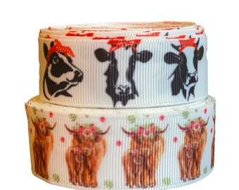 May include: Two rolls of white ribbon with cow print designs. The top roll features black and white cows wearing red bandanas. The bottom roll features brown cows with floral crowns and their calves.