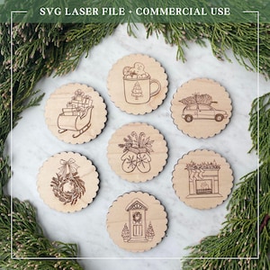 May include: A collection of seven wooden coasters with laser-etched Christmas-themed designs. The designs include a sleigh with gifts, a mug with a gingerbread man, a car with a Christmas tree, a wreath, mittens, a fireplace, and a decorated door. The text "SVG LASER FILE + COMMERCIAL USE" is at the top.