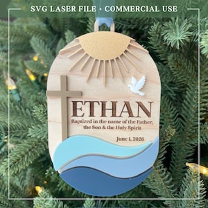 Puede incluir: Adorno de madera con el nombre "ETHAN" y el texto "Bautizado en el nombre del Padre, del Hijo y del Esp&iacute;ritu Santo 1 de junio de 2026." Presenta una cruz, una paloma y un dise&ntilde;o de sol. Incluye el texto "SVG LASER FILE + COMMERCIAL USE."