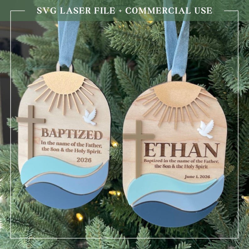 Puede incluir: Adornos de bautizo de madera con dise&ntilde;o de rayos de sol, cruz y paloma. Un adorno dice "BAPTIZED" y el otro dice "ETHAN". Ambos incluyen el texto "En el nombre del Padre, del Hijo y del Esp&iacute;ritu Santo" y una fecha. Incluye una cinta azul.