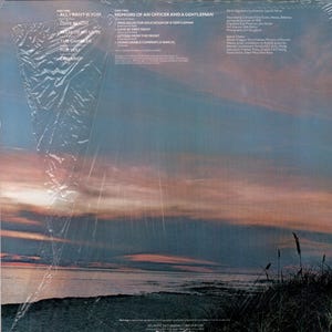 K&ouml;nnte beinhalten: Die R&uuml;ckseite einer Schallplatte mit einem Sonnenuntergang &uuml;ber dem Meer. Die Platte tr&auml;gt den Titel "Memoirs of an Officer and a Gentleman" von der Band "The Gambler". Die Trackliste umfasst "All I Want Is You", "Love Beach", "Mist of My Love", "The Gambler", "For You", "Prologue: The Education of a Gentleman", "Love at First Sight", "Letters from the Front" und "Honorable Company (A March)".