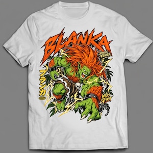 Op de afbeelding: Een wit t-shirt met korte mouwen en een grafische print van het personage Blanka uit Street Fighter. Het ontwerp toont het groenhuidige personage met oranje haar, omringd door gele bliksemschichten, groene bladeren en tekst.