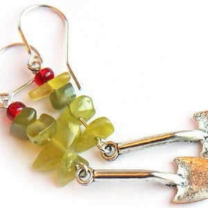 May include: A pair of silver earrings with green and red gemstone beads and silver spade-shaped charms.
