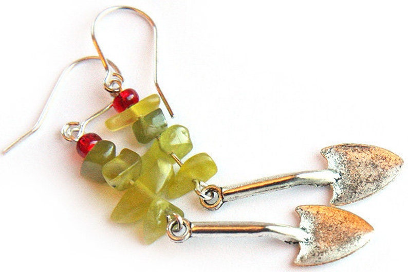 May include: A pair of silver earrings with green and red gemstone beads and silver spade-shaped charms.