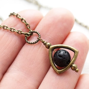 Op de afbeelding: Een bronzen ketting met een driehoekige hanger met een zwarte lavasteenkraal. De hanger is ontworpen om vrij te draaien.