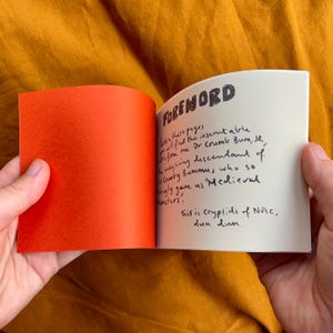 May include: A small, white book with a black handwritten foreword. The text reads "Foreword. Within these pages you will find the inscrutable story from one Dr Crumb Bum, Jr, the only living descendant of Cumby Bummus who so lovingly gave us Medieval monsters. This is cryptids of Norc, dun dun."