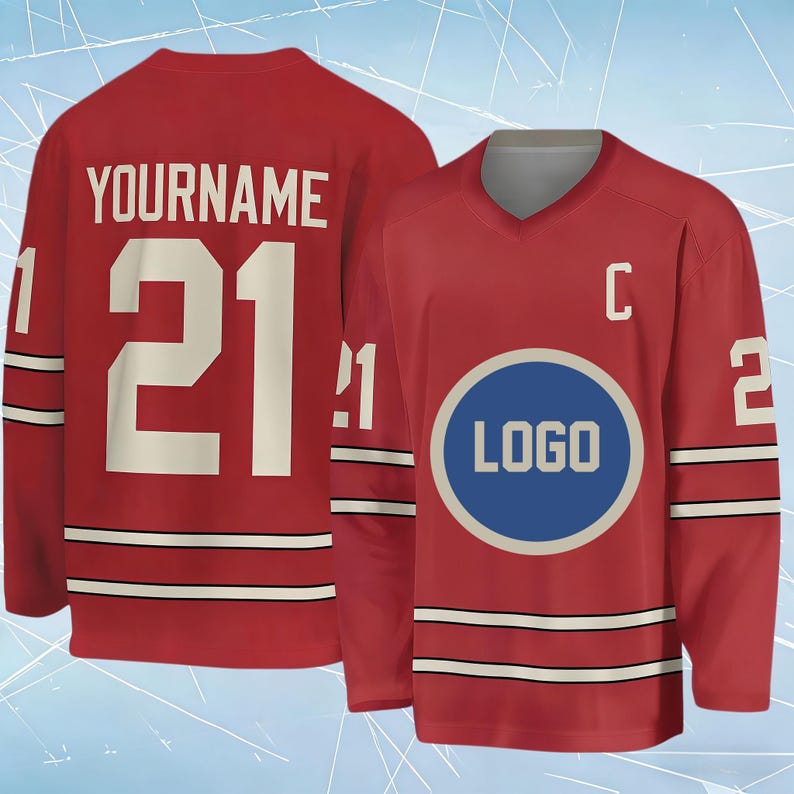 May include: A red hockey jersey featuring a V-neck collar, long sleeves with white and black stripes, and the number 21 on the back with the text YOURNAME. The front displays a blue circular logo, the letter C, and the number 21 on the sleeves.