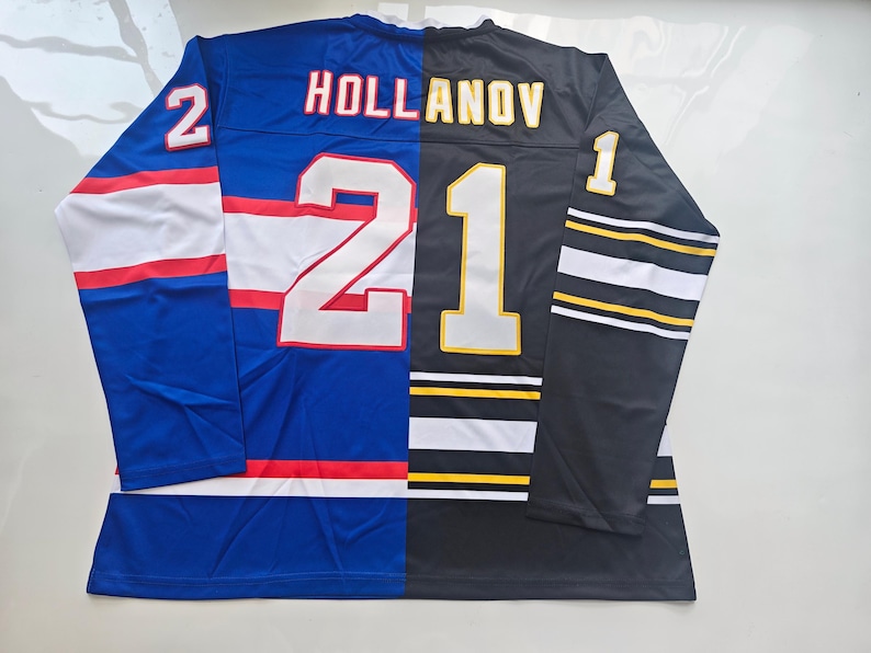 May include: A split-design hockey jersey featuring a blue left side with white and red stripes and a black right side with white and yellow stripes. The back displays the text HOLLANOV with the number 21, plus the number 2 on the left sleeve and 1 on the right sleeve.