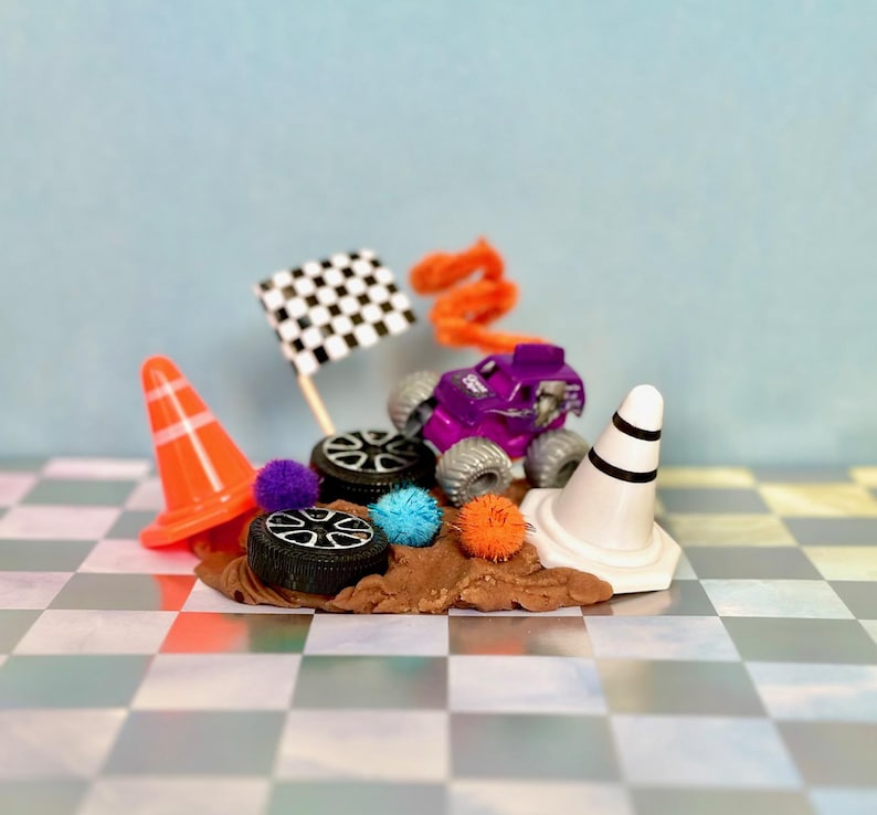 Monster Truck play dough jar featuring non-toxic play dough scented in cocoa.  Monster Jam theme accessories include two cones, two tires, flag, tinsel Pom poms and colorful pipe cleaner.  Great for sensory play, on the go/travel, screen-free entertainment.