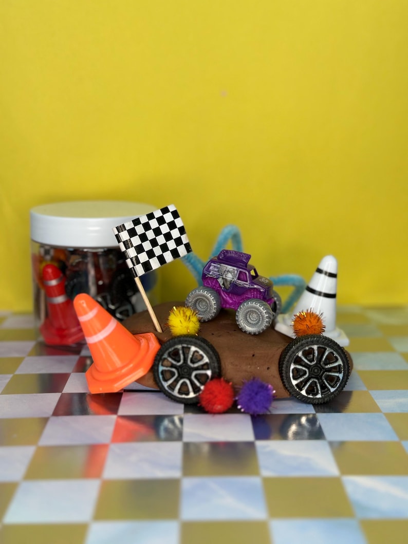 Monster Truck play dough jar featuring non-toxic play dough scented in cocoa.  Monster Jam theme accessories include two cones, two tires, flag, tinsel Pom poms and colorful pipe cleaner.  Great for sensory play, on the go/travel, screen-free entertainment.