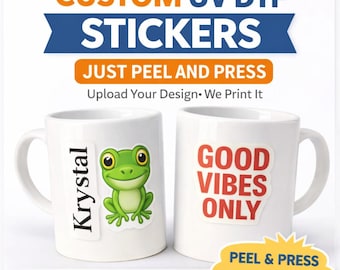 Puede incluir: Dos tazas de cerámica blanca con pegatinas UV DTF personalizadas. Una taza presenta una pegatina de rana verde, la otra dice "GOOD VIBES ONLY" en rojo. El texto "CUSTOM UV DTF STICKERS" está en la parte superior.