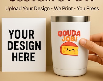 Puede incluir: Vaso blanco con borde plateado, con una pegatina "GOUDA JOB!" con una cuña de queso sonriente. Una tarjeta blanca muestra "YOUR DESIGN HERE" en letras negras en negrita. La imagen también incluye el texto "CUSTOM UV DTF" y "Stickers and Gang Sheets".