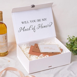 Pu&ograve; includere: Una scatola regalo rettangolare bianca con coperchio incernierato che presenta il testo stampato in nero WILL YOU BE MY Maid of Honor? La scatola &egrave; riempita con carta sminuzzata bianca, inserti in cartoncino marrone e un cartoncino bianco.